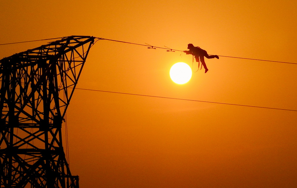 12月16日，施工人员在香涧至鹭岛500千伏线路工程施工现场进行高空作业（无人机照片）。