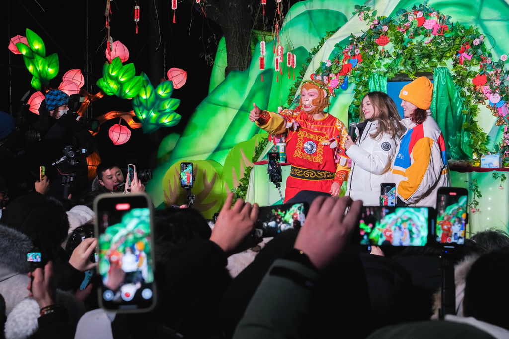 12月17日,外国媒体记者在长春市动植物公园与西游记主题表演演职人员进行互动。