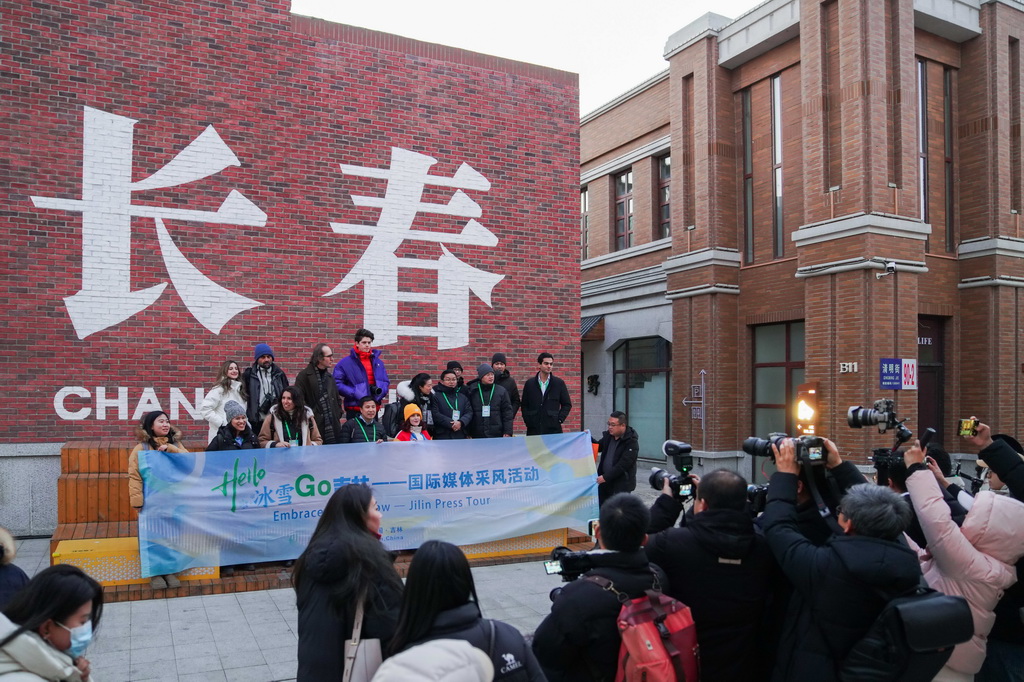 12月17日,国际媒体采风团在长春市春京西历史文化街区合影留念。