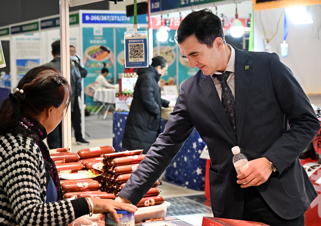 12月19日,一名客商在博览会上了解食材配料。