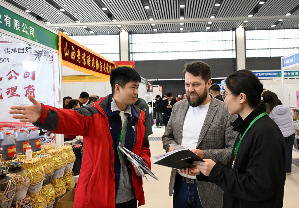 12月19日,客商在博览会上交流洽谈。