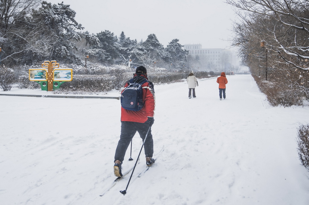 12月23日，一名長春市民踩著滑雪板冒雪出行。