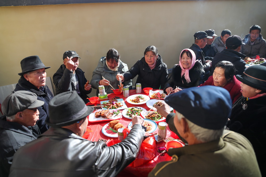 12月29日,村民在榆中縣馬坡鄉馬蓮灘村集中安置點參加一場喬遷宴。
