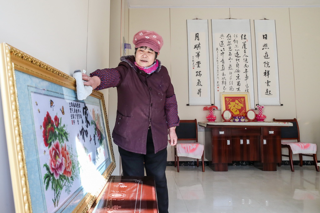 12月29日,村民趙玉真在榆中縣馬坡鄉馬蓮灘村集中安置點的新家裡打掃衛生。