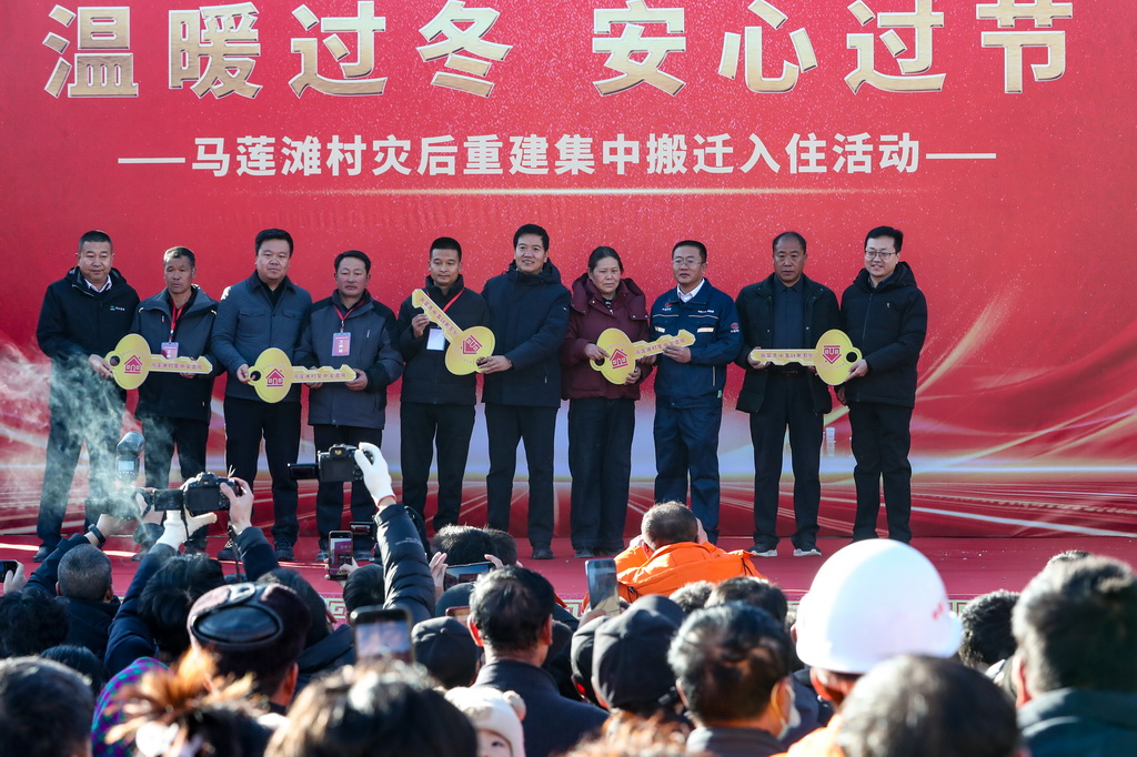 12月29日,在榆中縣馬坡鄉馬蓮灘村災后重建集中搬遷入住活動現場,建設單位代表與群眾代表舉行交付新房鑰匙儀式。