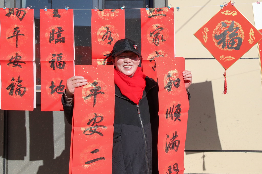 12月29日,村民在榆中縣馬坡鄉馬蓮灘村災后重建集中搬遷入住活動現場領取春聯。