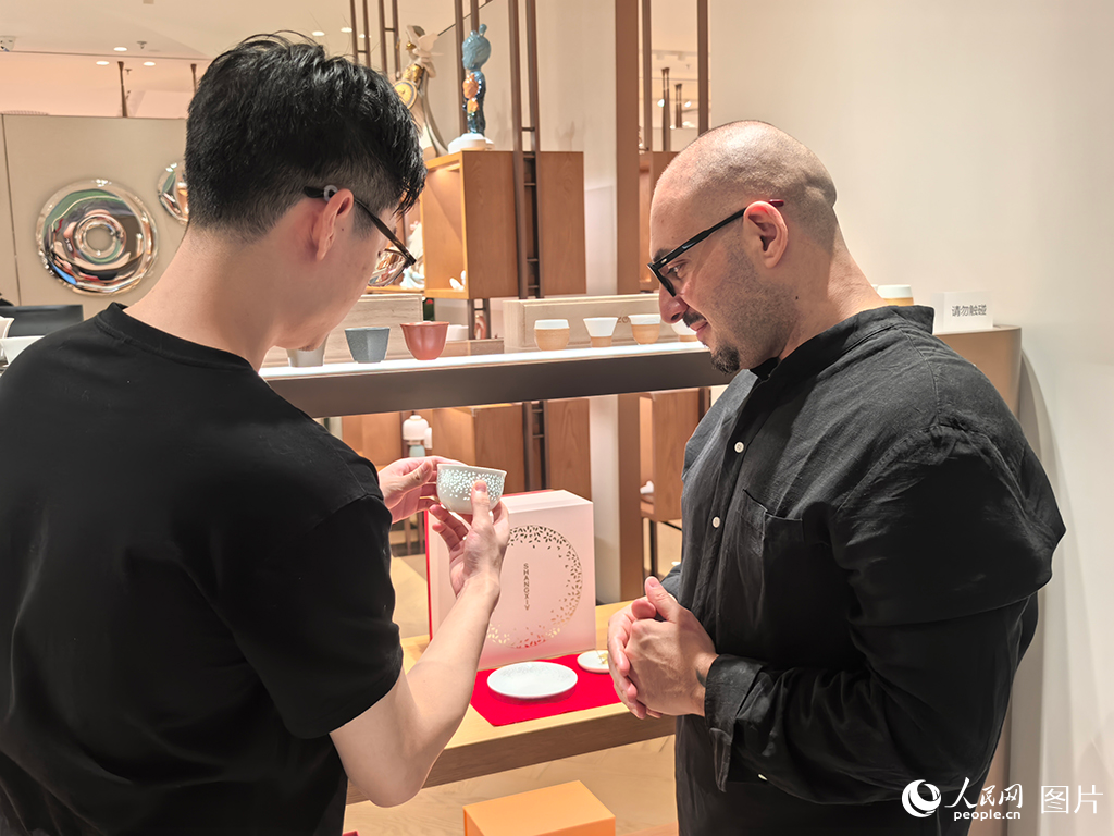 2025年国庆中秋双节期间，来自意大利的拉斐尔正在武汉SKP商场选购离境退税商品，他看中一套景德镇茶具，计划作为礼物送给家人。人民网记者 周恬摄