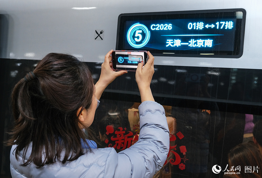 12月30日，旅客在站台用手機拍攝C2026次列車車次留作紀念。