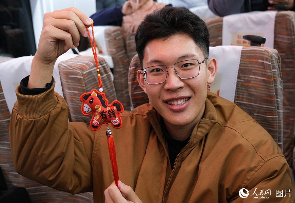 12月30日，C2026次列車上旅客展示新年紀念禮品。