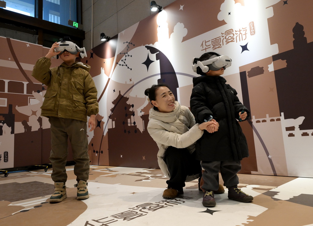 1月3日，小观众在中国考古博物馆“华夏漫游”互动项目区使用VR设备观看北京中轴线场景介绍。