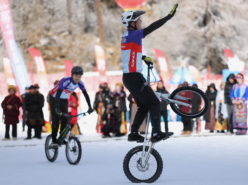 1月5日,在理縣畢棚溝滑雪場,兩名表演者在雪地裡進行山地車表演。