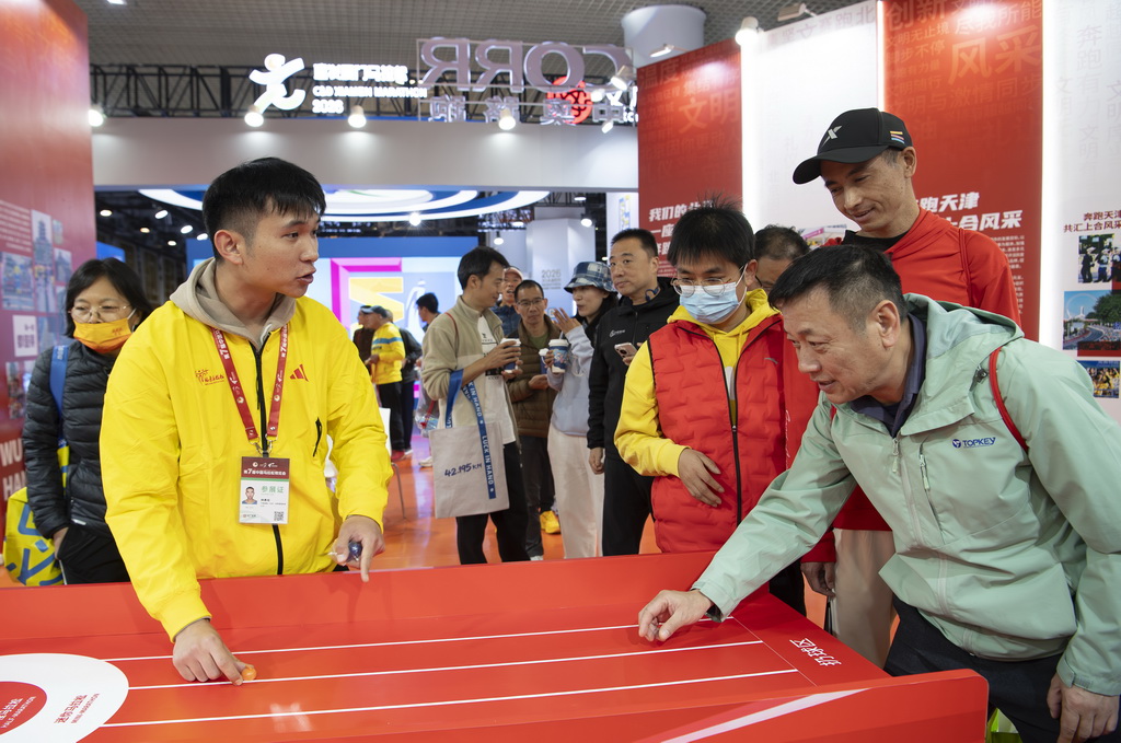 1月8日,厦门马拉松赛选手在博览会现场参加互动游戏。