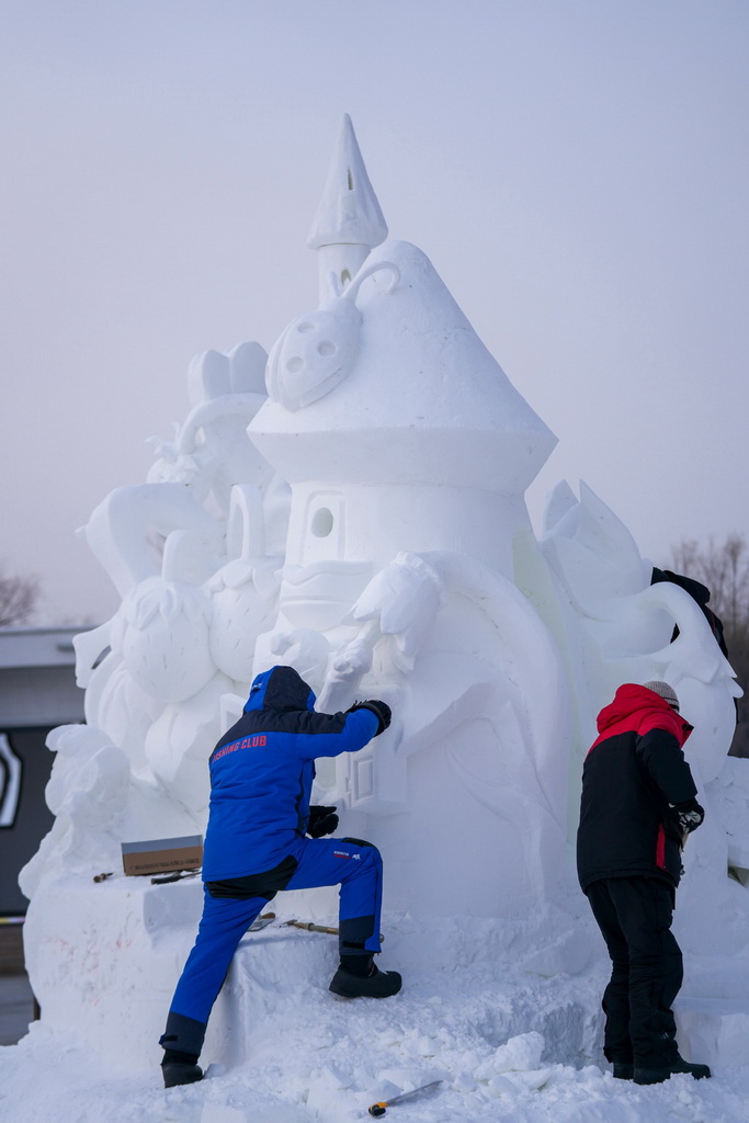 1月8日，在哈爾濱太陽島雪博會第28屆中國·哈爾濱國際雪雕比賽現場，選手進行雪雕創作。