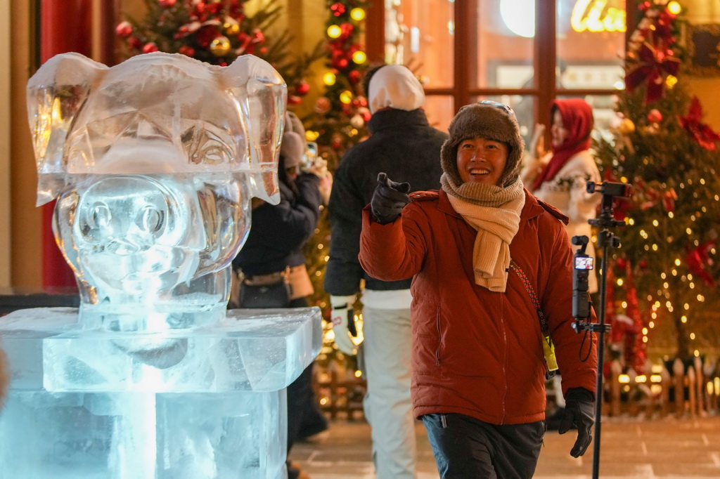 1月13日，游客在中华巴洛克历史文化街区兽首冰雕旁拍照。新华社记者 王建威 摄