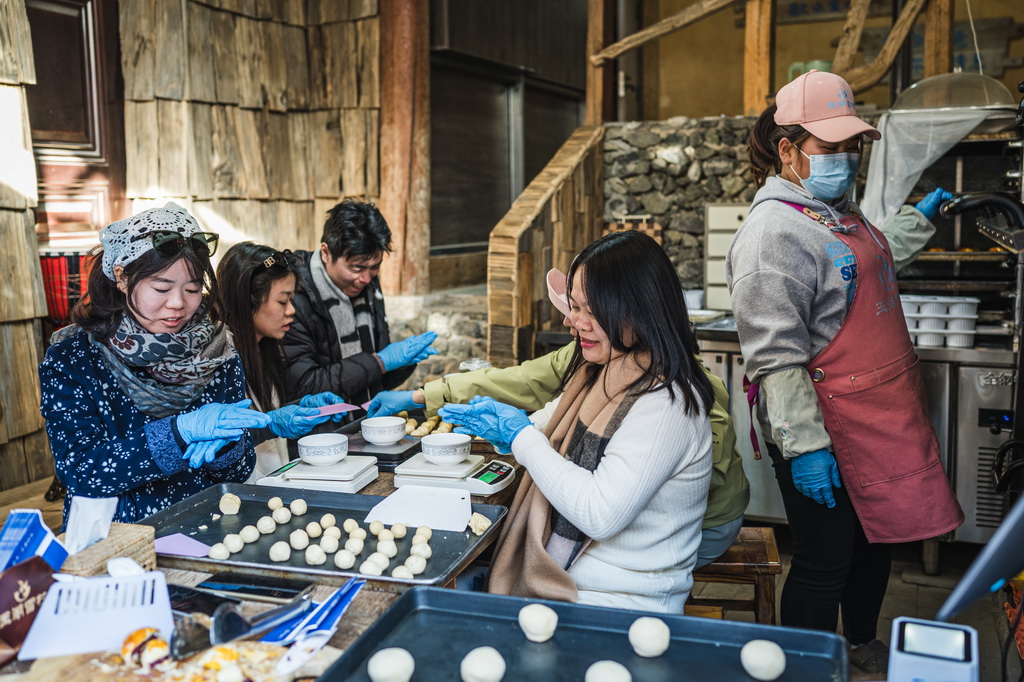 1月17日,游客在丽江市玉龙纳西族自治县白沙镇玉湖村体验制作鲜花饼。新华社记者 王冠森 摄