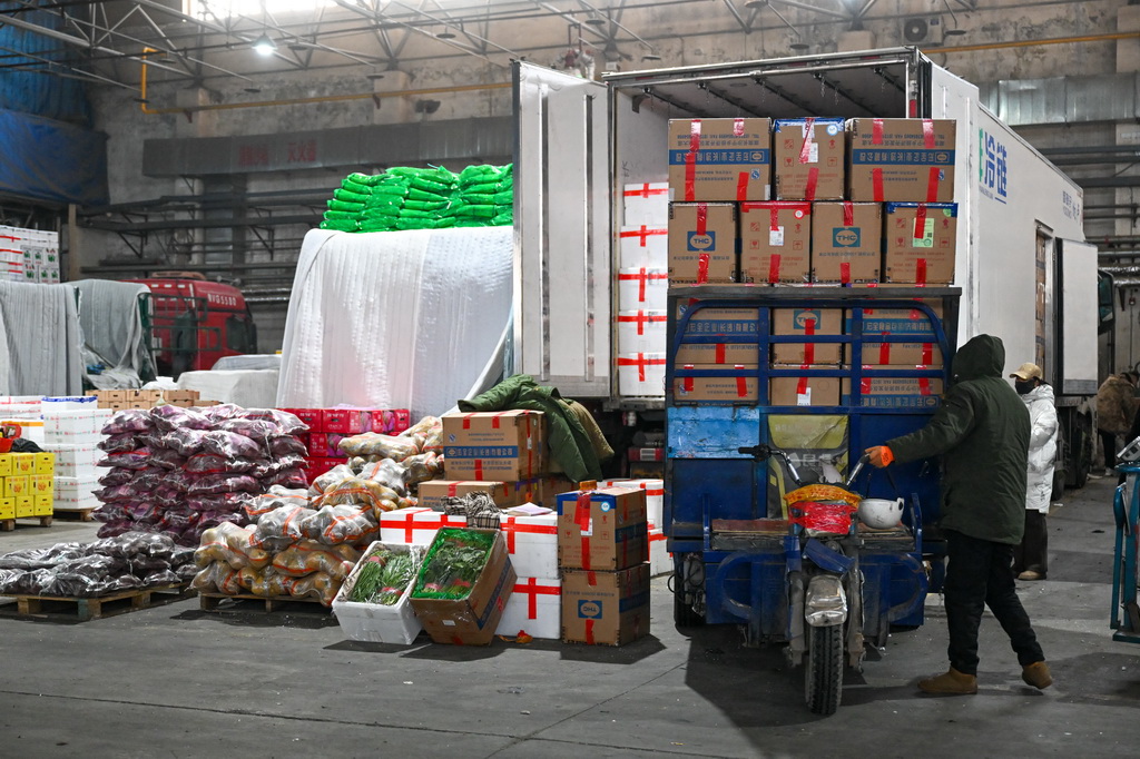 在新疆乌鲁木齐市九鼎农产品批发市场蔬菜交易中心，商户接车准备卸菜（1月19日摄）。