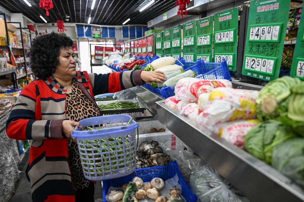 在新疆乌鲁木齐市水磨沟区六道湾街道南湖花苑社区蔬菜副食品直销点，市民在选购蔬菜（1月20日摄）。