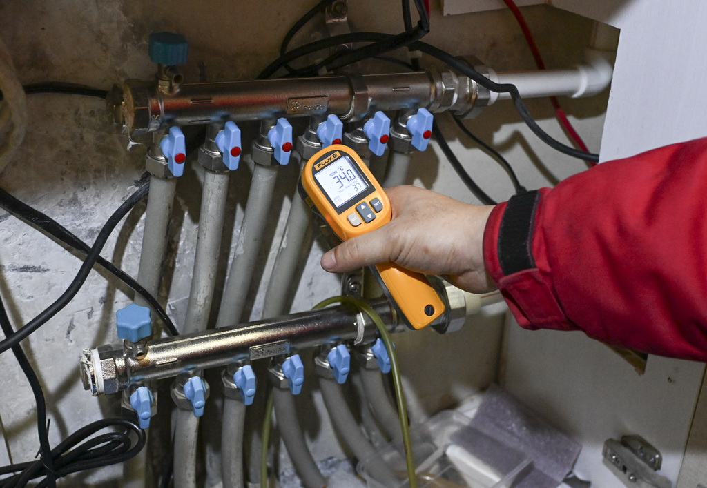 乌鲁木齐热力（集团）有限公司第一供热公司工作人员在辖区居民家中检查供热设施（1月18日摄）。