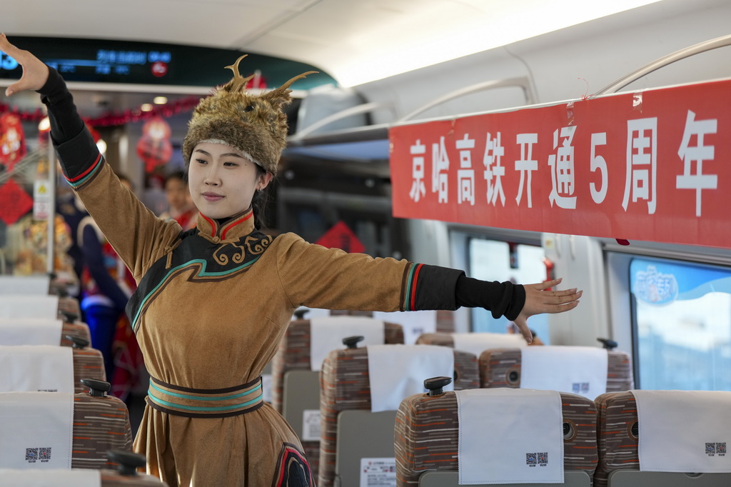 1月22日,乘務員在G902次動車組列車車廂中為旅客表演民俗舞蹈。