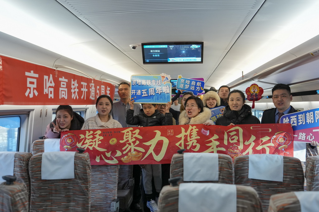 1月22日,旅客與乘務人員在G902次動車組列車車廂中合影。