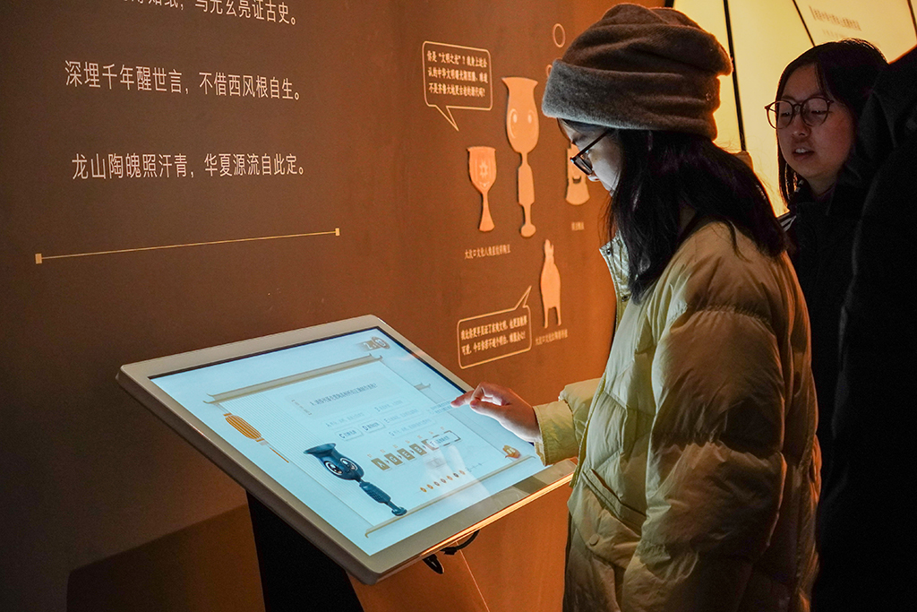 1月27日，觀眾在山東博物館參觀“對話蛋殼黑陶高柄杯”明星文物展。新華社記者 徐速繪 攝