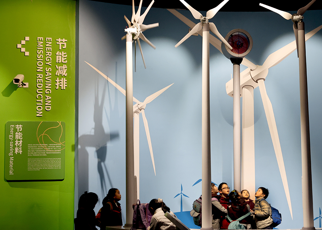 1月27日,小朋友在上海科技馆“源动未来”展区内一组风电模型下参观。
