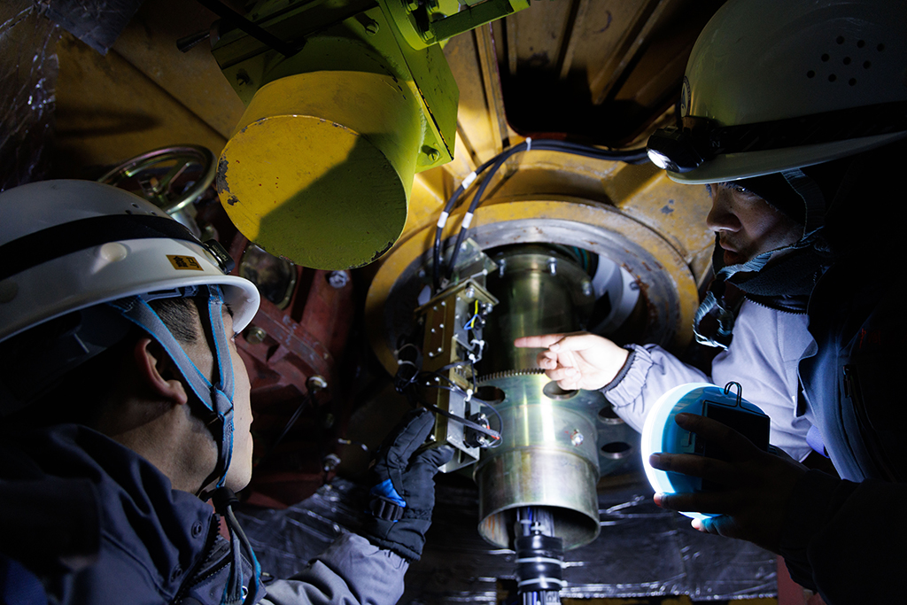 1月24日,工作人員李強(右)和田冬在衛星數據接收系統方位艙進行設備維護。