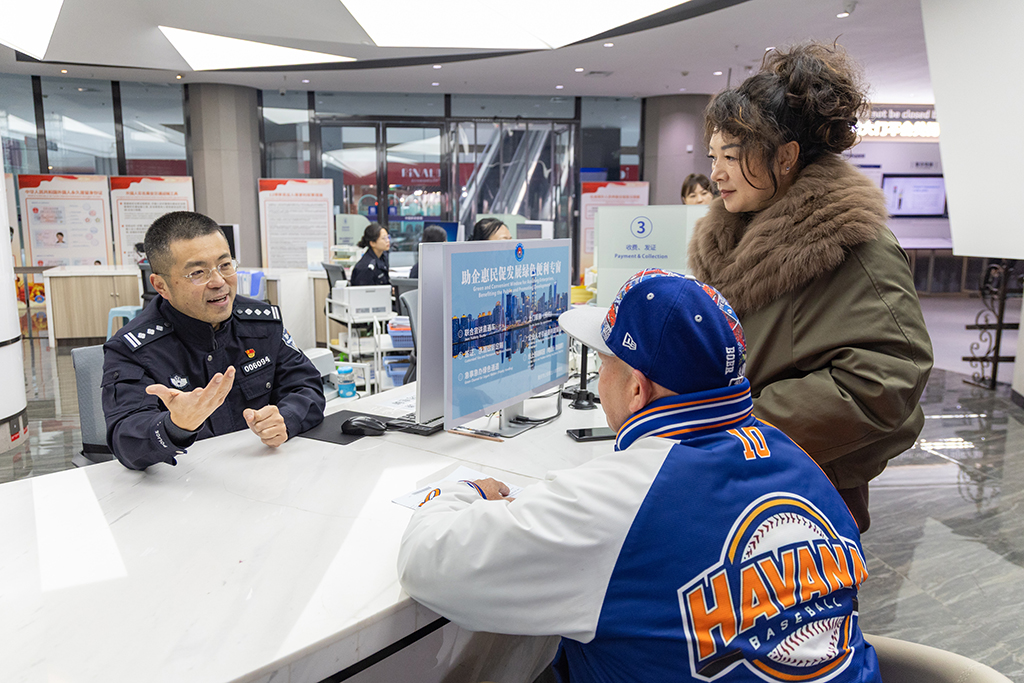 在重慶市公安局出入境管理局移民事務服務中心，民警為外籍人員解答相關永居政策（1月27日攝）。