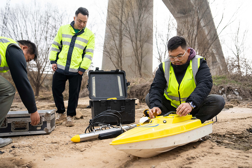 1月29日，在滬昆高鐵湘江特大橋下，鐵路工人組裝無人測量船准備檢測河床情況。