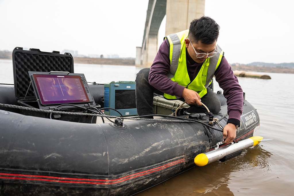 1月29日,在滬昆高鐵湘江特大橋下,鐵路工人在汽艇上安裝聲吶檢測系統准備進行水下墩身成像作業。