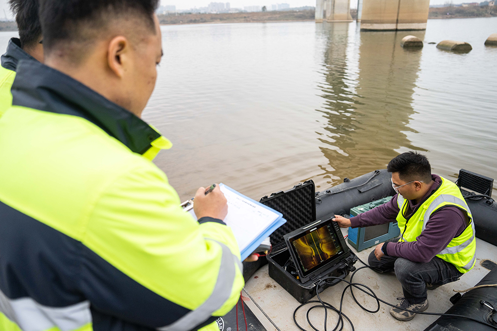 1月29日，在滬昆高鐵湘江特大橋下，鐵路工人在記錄聲吶檢測系統反饋回來的畫面及數據。
