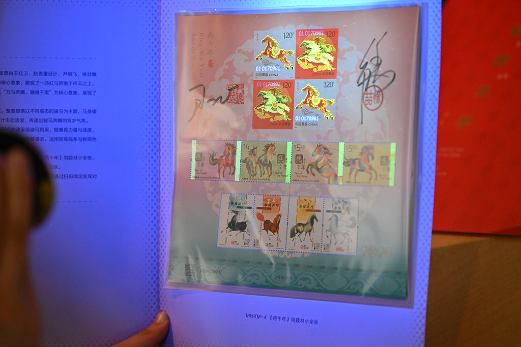 這是紫光燈照射下的《駿馳元宇》郵票珍藏冊內郵票呈現的熒光油墨印制工藝效果(1月29日攝)。
