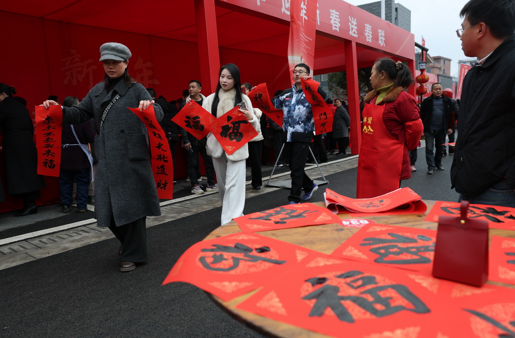 1月31日，在四川省宜賓市筠連縣沐愛鎮金坪村搬遷安置區，受災群眾領取春聯。