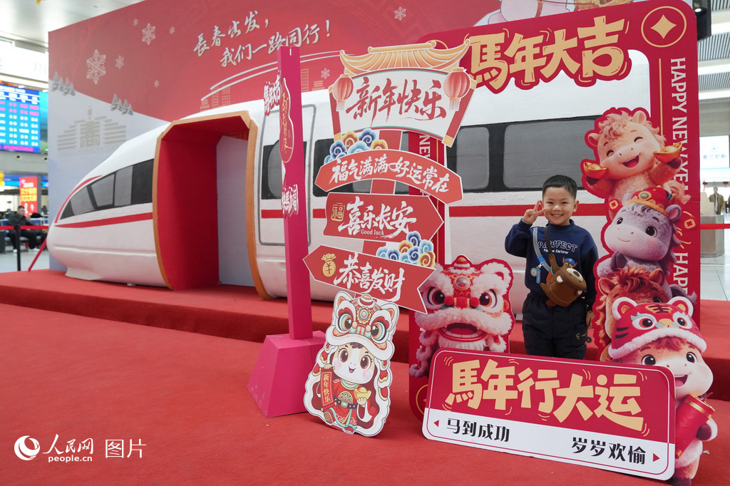 2月2日，長春火車站候車大廳內，馬年新春主題裝飾格外喜慶。一名小朋友在“馬年大吉”等新春祝福語前駐足留影。人民網記者 李洋攝