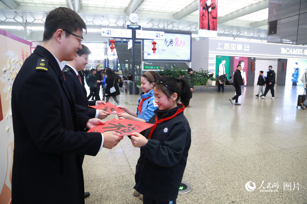 2月2日，春運首日，上海虹橋火車站兩名小學生參加“新春送福”活動，寫下兩幅“福”字送給虹橋站的工作人員。人民網記者 龔莎攝
