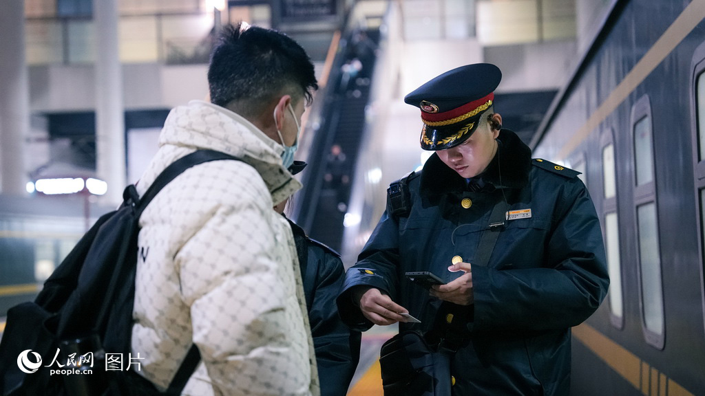 2月2日，銀川火車站，K1297次列車的乘務員正在車廂門口核驗席位，迎接旅客乘車。人民網記者 梁宏鑫攝