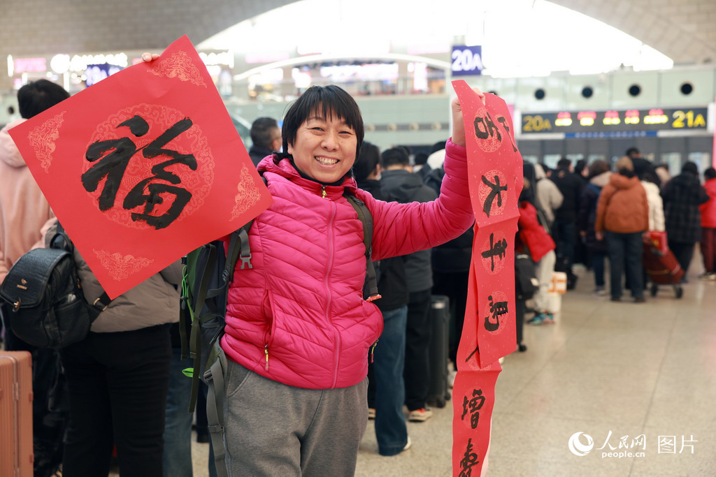 2月2日，河北石家庄站書法公益活動現場，旅客收到福字和春聯后開心的向記者展示。人民網記者 李兆民攝
