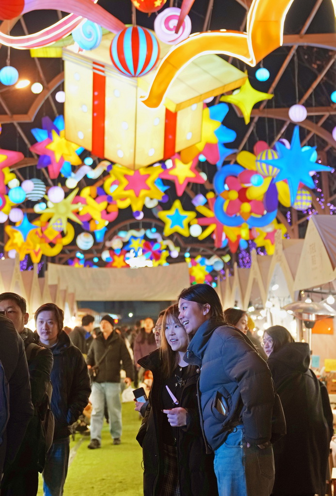2月1日晚,游客在外滩枫径年味集市休闲游览。