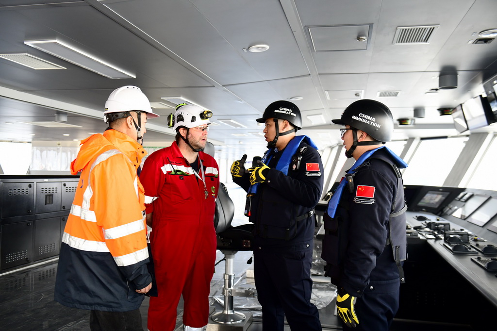 2月3日,在中集来福士山东烟台建造基地,山东出入境边防检查总站烟台边检站来福士警务室的民警对即将离港的比利时风电安装船进行船体检查,并与船员交流。