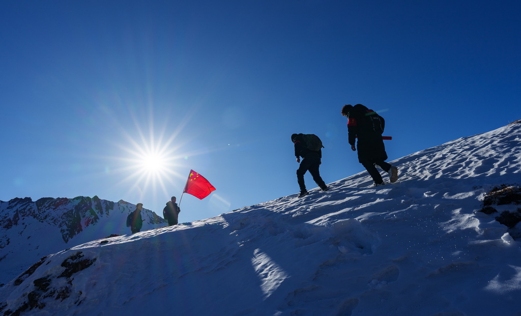 在西藏山南市隆子县玉麦乡境内,护边员们在雪坡上巡逻(2月6日摄)。