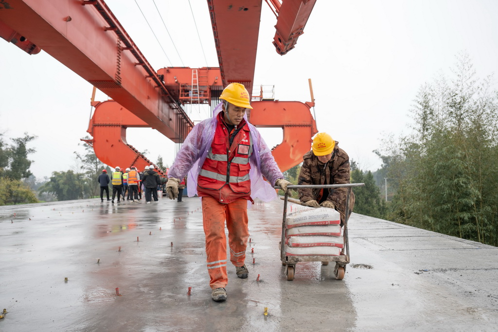2月9日,工人們在箱梁架設現場作業。