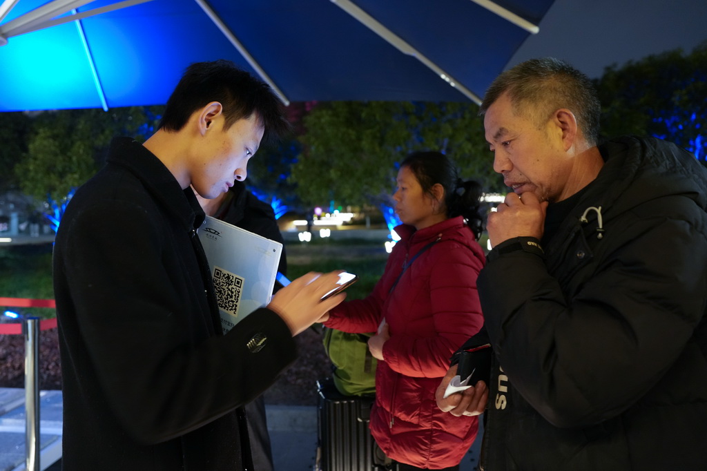 2月10日，“星辰守護”旅客夜間休息區的工作人員協助一位重慶旅客登記信息。