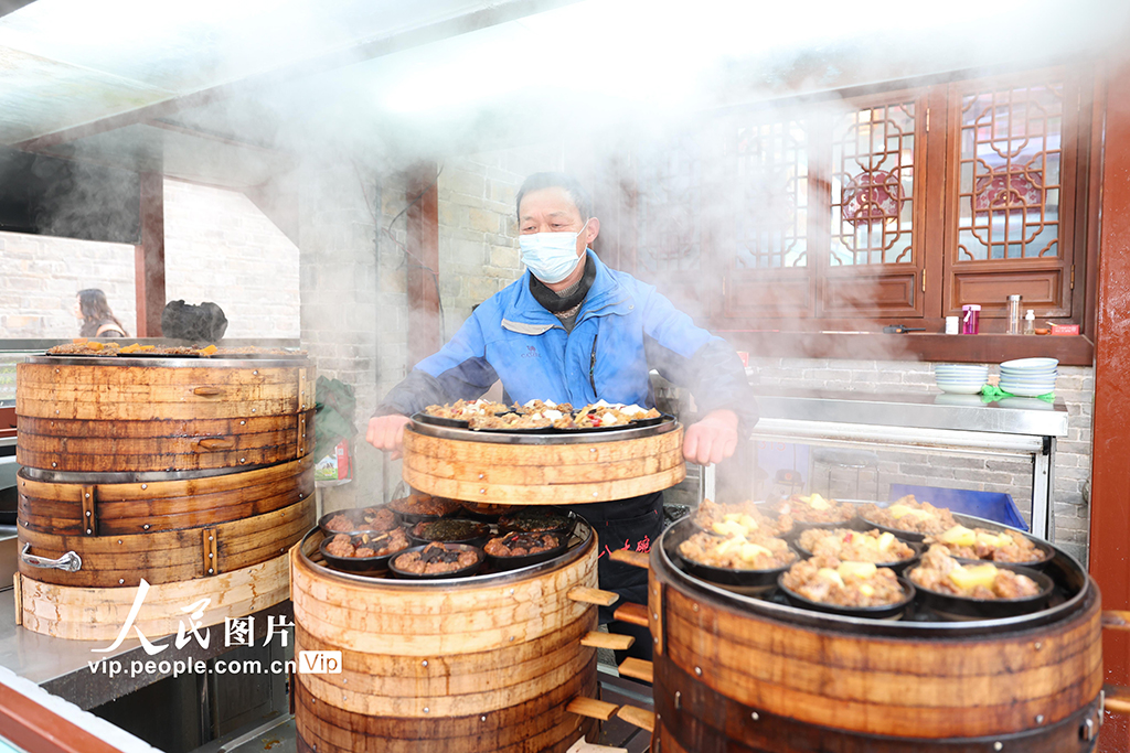 2026年2月10日,湖北襄陽古城張燈結彩,商家為顧客備好“襄陽八大碗”特色蒸菜,年味濃郁。楊東攝(人民圖片網)