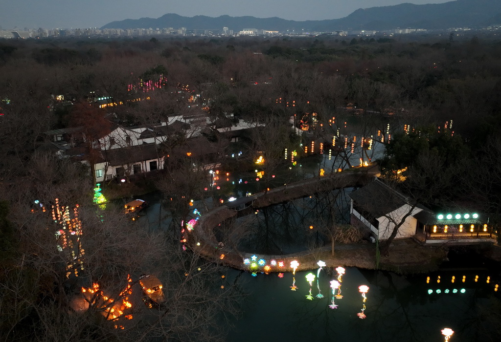 2月11日,游客在西溪湿地乘船体验水上赏灯(无人机照片)。