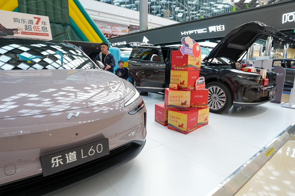 2月11日,在北京市朝阳区一个商场内,市民在了解新能源汽车。