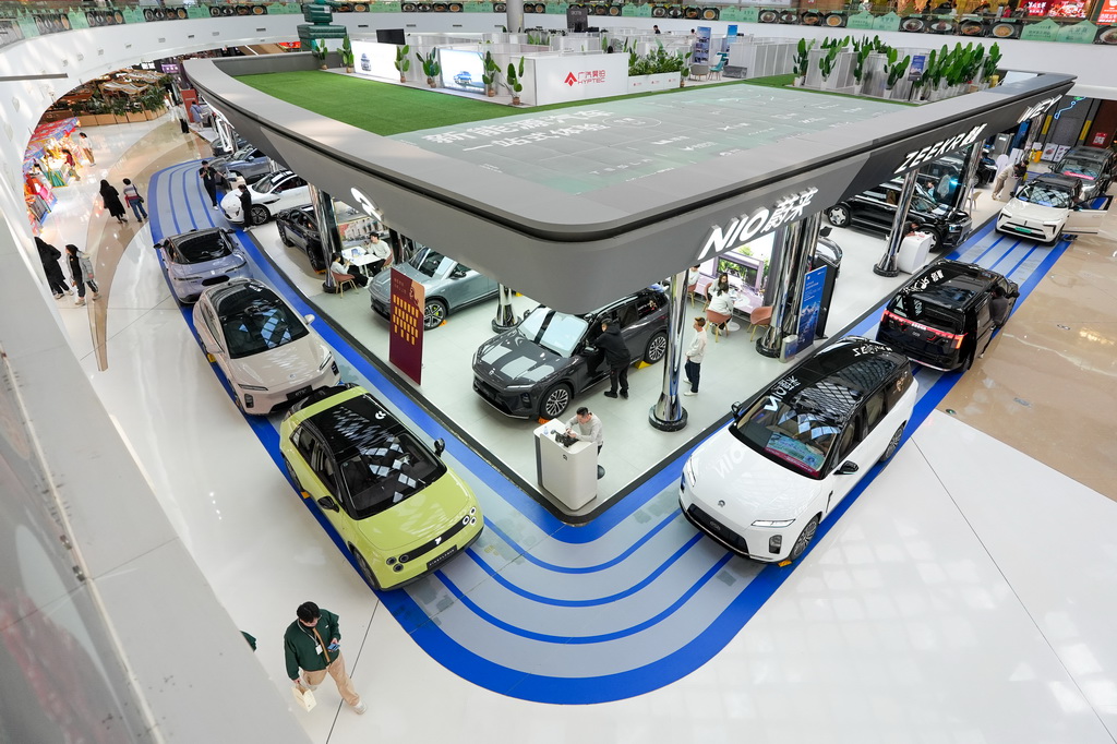 2月11日,在北京市朝阳区一个商场内,市民在了解新能源汽车。