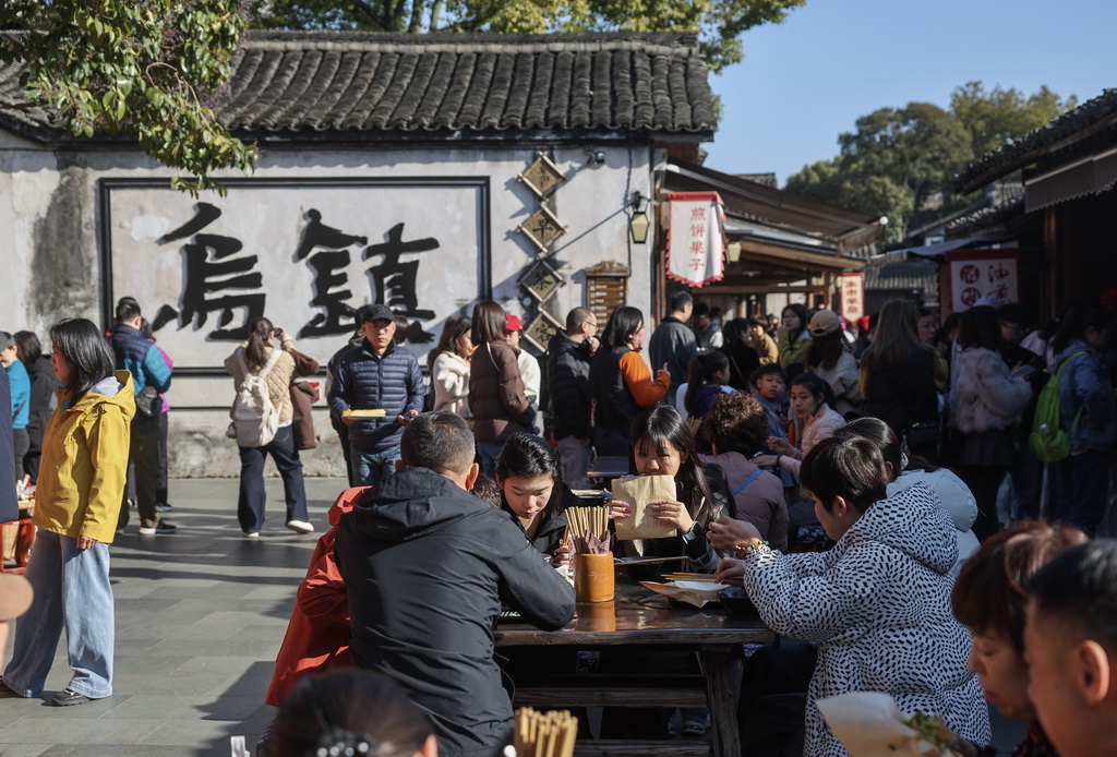 2月21日，游客们在乌镇早市上吃早餐。