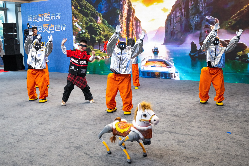 2月24日，小朋友与人形机器人在现场一起表演。