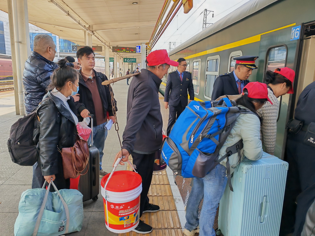 2月24日,在云南省曲靖站,务工人员有序上车。