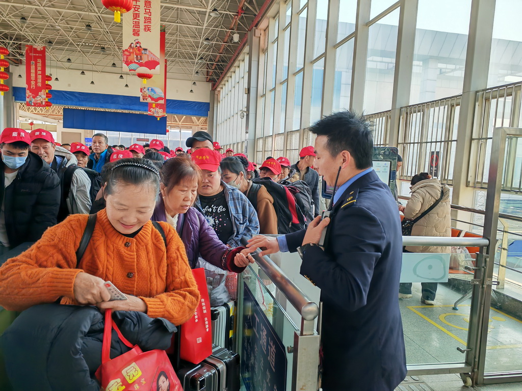 2月24日,在云南省曲靖站,务工人员检票进站。